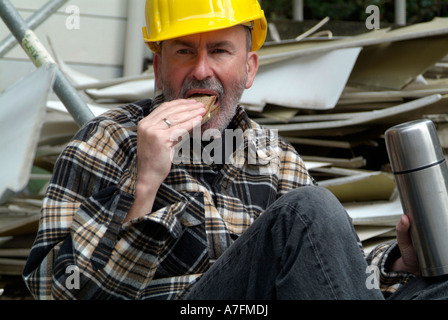 MR worker at building site having a break pause eating a bread sandwich Stock Photo