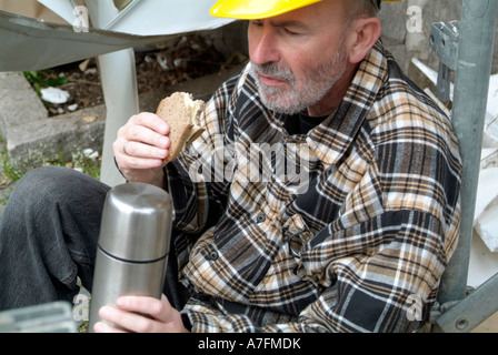 MR worker at building site having a break pause eating a bread sandwich Stock Photo
