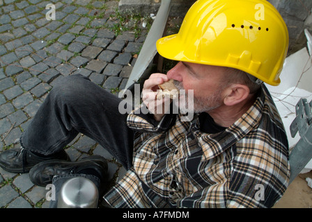 MR worker at building site having a break pause eating a bread sandwich Stock Photo