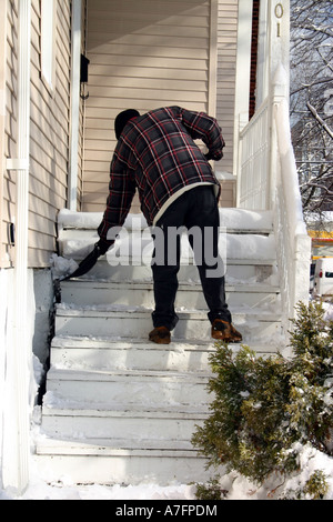 Man shoveling his front steps after snowfall Chicago Illinois Stock Photo