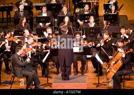 Music Director Kimo Furumoto directs student musicians or the California State University Fullerton Orchestra in a concert Stock Photo