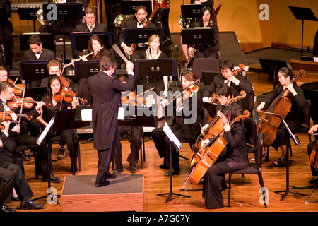 Music Director Kimo Furumoto directs student musicians or the California State University Fullerton Orchestra in a concert Stock Photo