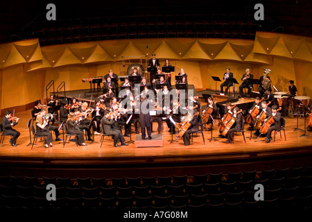 Music Director Kimo Furumoto directs student musicians or the California State University Fullerton Orchestra in a concert Stock Photo