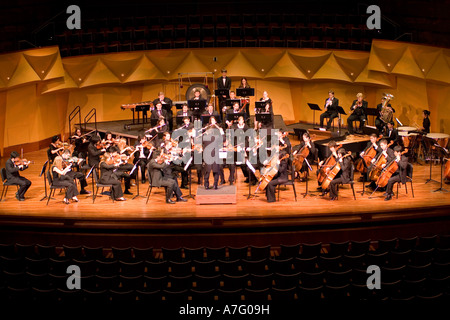 Music Director Kimo Furumoto directs student musicians or the California State University Fullerton Orchestra in a concert Stock Photo