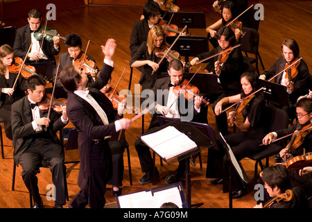 Music Director Kimo Furumoto directs student musicians or the California State University Fullerton Orchestra in a concert Stock Photo