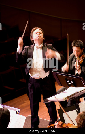 Music Director Kimo Furumoto directs student musicians or the California State University Fullerton Orchestra in a concert Stock Photo