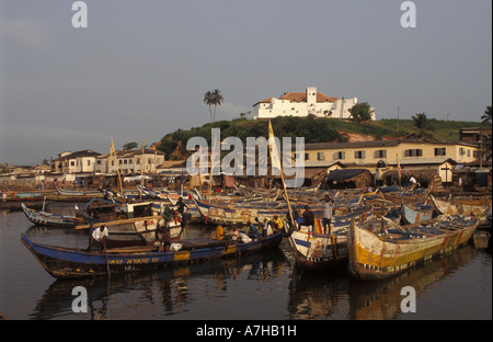 Fishing pirogues in the harbour with Fort St Jago on the hill, Elmina, Ghana Stock Photo