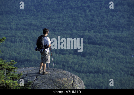 North America, US, ME, A hiker stands on a ledge near the west peak of Tumbledown Mountain. Northern Forest. (MR) Stock Photo