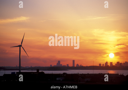 North America, US, MA, Hull, Wind Turbine in Hull, Massachusetts.  The Boston skyline is in the distance. Sunset. Stock Photo