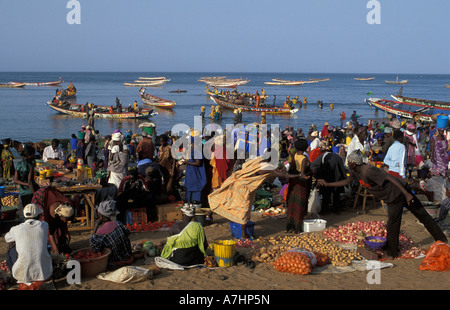 Fish market on the beach with pirogues coming in with fresh fish Petit Côte Mbour Senegal Stock Photo