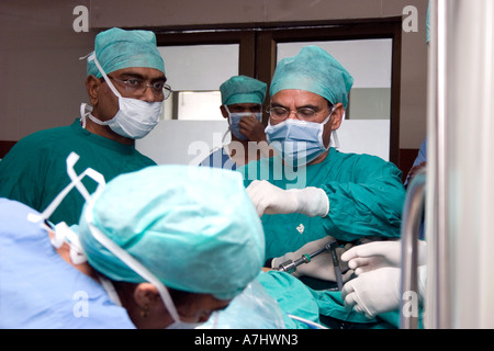 A group of surgeons and nurses in-between surgery inside the operation theater Stock Photo