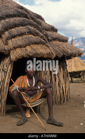 Karimojong boy at his hut in a village at the base of Mount Kadam 3068m Uganda Stock Photo