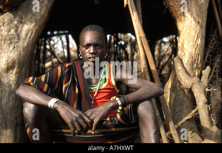 Karimojong boy at his hut in a village at the base of Mount Kadam 3068m Uganda Stock Photo