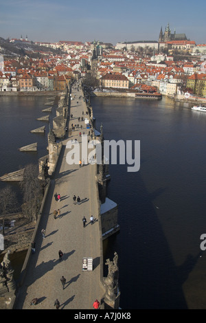Charles Bridge Prague bright winter day looking down from old town tower Prague Castle and St Vitus Cathedral on skyline Stock Photo