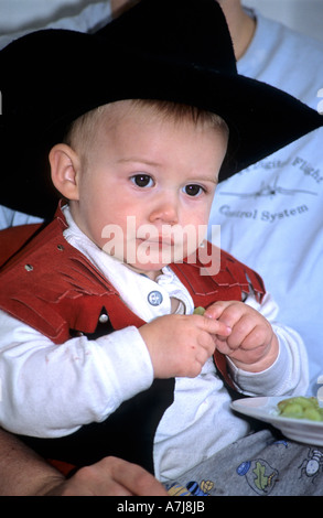 child dressed as a cowboy , eating grapes Stock Photo