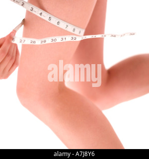 A young woman measuring her thigh Stock Photo