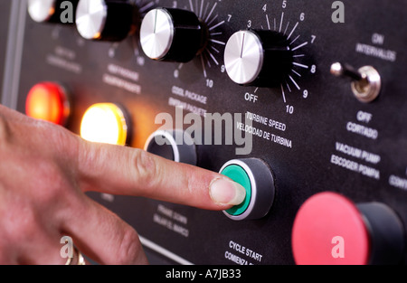 Factory worker pushing button on sealing machine Stock Photo