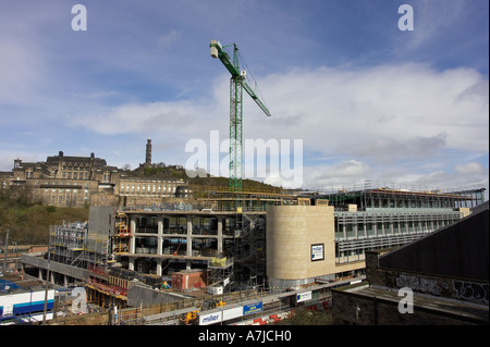 Construction ongoing on new City of Edinburgh Council Headquarters at waverley court with crane in a cloudy blue sky over building site Stock Photo