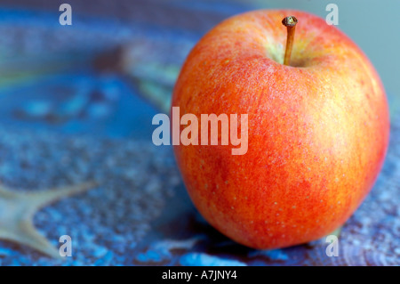 Bright red apple on a blue background Stock Photo