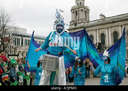 blue stilt walker with drum and followers taking part in St Patricks Day parade in Belfast 2007 Stock Photo