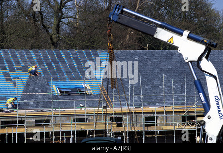 Tiles being laid on the roof of a new NHS health centre, Woodbridge, Suffolk, UK. Stock Photo
