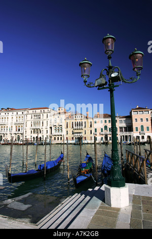 Typical view of Venetian gondolas on Grand Canal near St Marks Square with ornate iron lamp post Venice Italy Europe EU Stock Photo