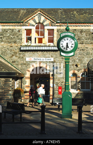 People and clock outside Betws y Coed train railway station stone building entrance Conwy Snowdonia National Park North Wales UK Stock Photo