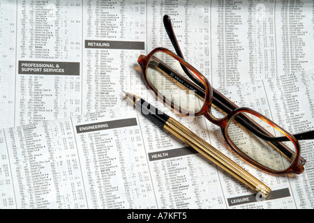 checking list of stocks and shares markets in detail on newspaper page equity prices lens lenses focus Stock Photo