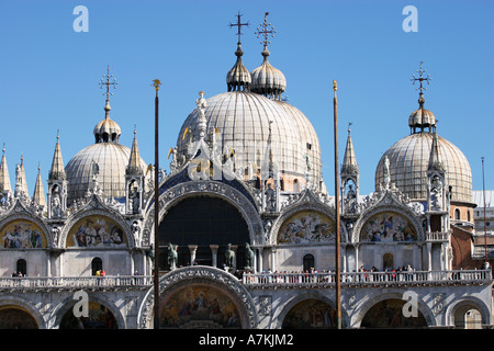 Tourists explore the fine mosaics facade of St. Marks Basilica on the first floor balcony, Saint Marks Square Venice Italy EU Stock Photo