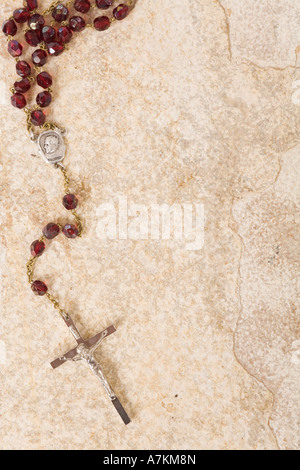 Rosary beads on a sandstone background with space for text Stock Photo