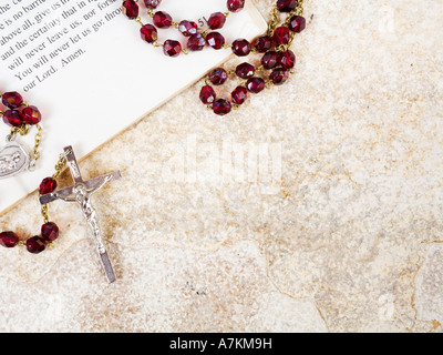 Rosary beads on a book of psalms and sandstone background with copy space Stock Photo