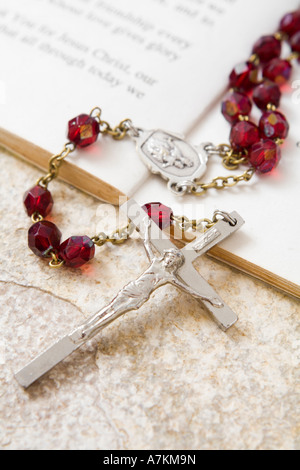 Rosary beads on a book of psalms and sandstone background Stock Photo