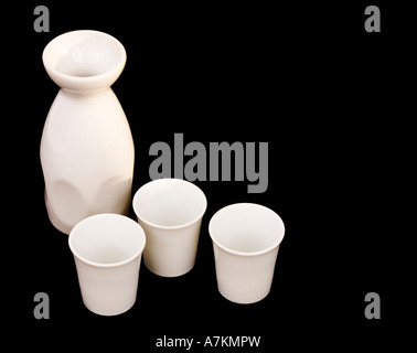 Sake jug and cups isolated on black with copy space Stock Photo