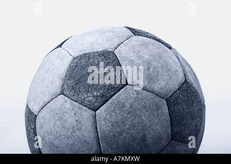 Old battered soccer ball on white background, cut out, black and white image, blue toned, football relegation Stock Photo