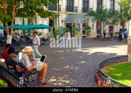 A tourist using a laptop in Hidalgo park, Merida Stock Photo