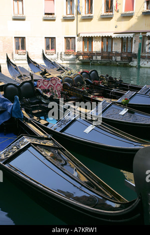 Evocative Venetian gondola boats moored outside an expensive luxury hotel central Venice Italy European destination Stock Photo