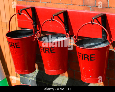 Red fire buckets filled with sand Stock Photo