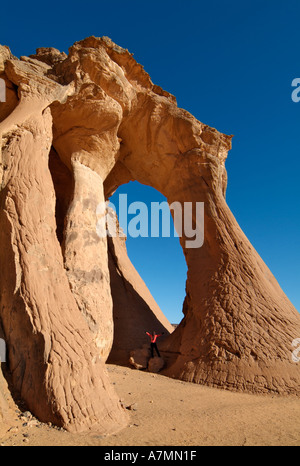 Tourists exploring a natural arch, Jebel Acacus, Sahara Desert, Libya Stock Photo