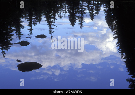 Reflection of sky, trees, rocks, and clouds in Russel Lake, Mt. Jefferson Wilderness, Oregon Stock Photo