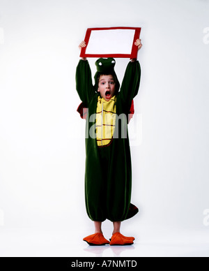 indoor studio child boy 5 10 outfit disguise costume crocodile aligator carnival ball kinderball party stand hold board rise Stock Photo