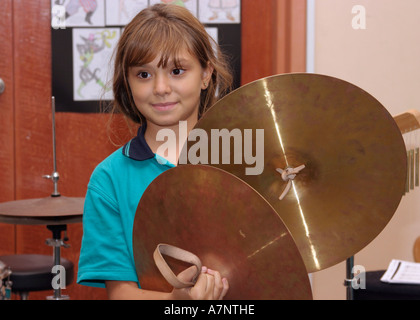 young girl playing cymbals in music lesson at school Stock Photo
