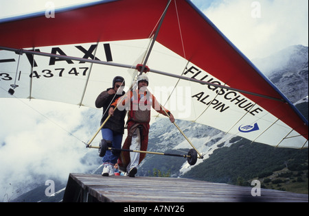 Hang glider taxi - an Austrian hang glider pilot and his passenger run down the takeoff ramp Stock Photo