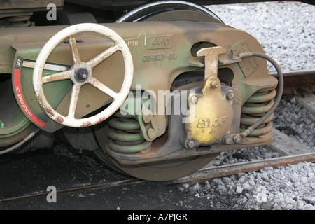 Large bogie on modern rail wagon showing manual wheel handbrake. Stock Photo