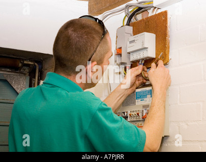an electrician installing a new style domestic electricity meter Stock Photo