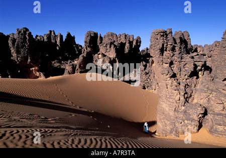 Libya, Desert region, Fezzan (Sahara), Tassili of Maghidet , Tuareg walking between sandstones needles (Algerian frontier) Stock Photo