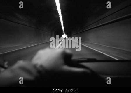 First person view of a person driving an auto through a tunnel Stock Photo