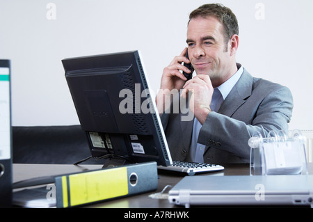Businessman using computer and mobile phone Stock Photo