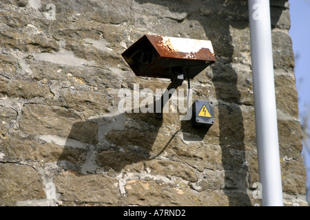 Hopelessy rusty and useless CCTV security camera on wall of local pub Stock Photo