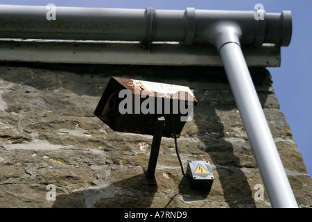 Hopelessy rusty and useless CCTV security camera on wall of local pub Stock Photo