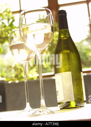 Low angle view of glasses and bottle of white wine Stock Photo